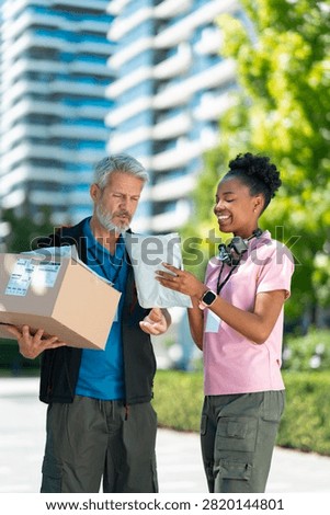 Delivery workers inspect package information to ensure accurate and efficient last-mile delivery.