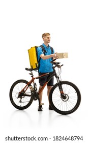 Deliveryman With Bicycle Isolated On White Studio Background. Contacless Service During Quarantine. Man Delivers Food During Isolation. Safety. Professional Occupation. Copyspace For Ad.