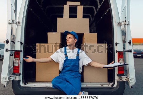 Deliveryman at the\
car, boxes in a pyramid\
shape