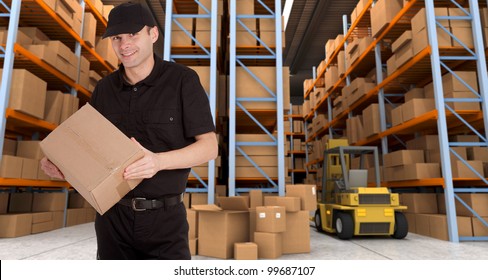 Deliveryman carrying a parcel in a distribution warehouse