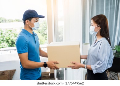 Deliveryman Delivering Package Box Parcel Giving To Female Customer At Home Wearing Face Mask Safety Coronavirus Covid-19 Infection Customer Delivery Service Logistics Ordering Mail Posting Business  