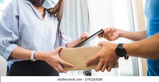 Deliveryman Delivering Package Food Order Customer At Home Signing Signature On Tablet Wearing Face Mask Safety Covid-19 Infection Customer Delivery Service Logistics Ordering Mail Posting Business