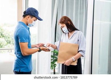 Deliveryman Delivering Package Food Order Customer At Home Signing Signature On Tablet Wearing Face Mask Safety Covid-19 Infection Customer Delivery Service Logistics Ordering Mail Posting Business  