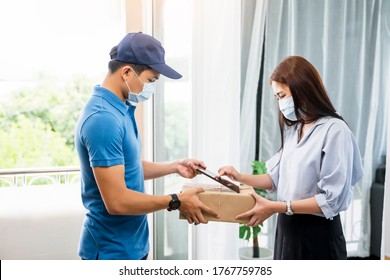 Deliveryman Delivering Package Parcel Box Customer At Home Signing Signature On Tablet Wearing Face Mask Safety Covid-19 Infection Customer Delivery Service Logistics Ordering Mail Posting Business  