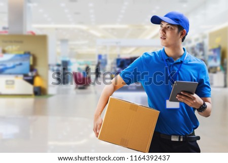 deliveryman holding box and using digital tablet