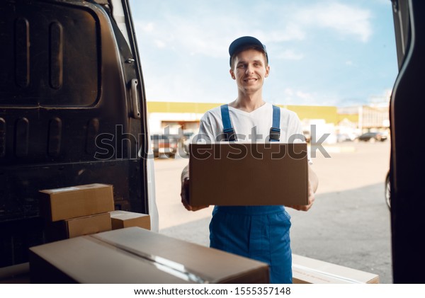 Deliveryman\
unloads the car with parcels,\
delivery