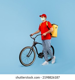 Deliveryman Wearing Face Mask Standing With Bike Looking Aside Delivering Food From Restaurant Posing Over Blue Background. Transportation Offer And Courier Service Concept. Square, Studio Shot - Powered by Shutterstock