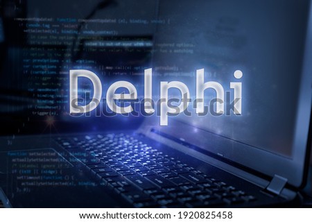 Delphi inscription against laptop and code background. Learn programming language, computer courses, training. 