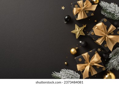 Deluxe holiday wishes concept. Top view of luxurious gift packages, costly tree trimmings, gold and black balls, sparkling confetti, frosted fir twigs on dark backdrop with space for festive words