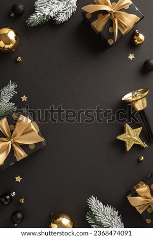Deluxe New Year gift shopping concept. Vertical top view of lavish gift boxes with exquisite wrappings, black, gold balls, tinkling bell, frosty fir twigs, black background with space for advertising