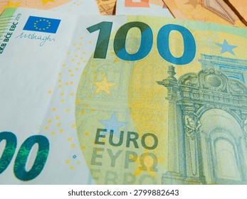 Delve into the intricate design elements of a 100 euro banknote, showcasing its colorful patterns, security features, and fine artistry. Explore the composite details up close.