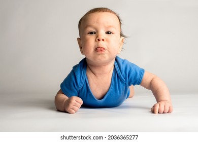 Demanding, Wayward, Stubborn, Baby. Baby In Blue Clothes On A White Background.