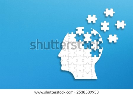 Dementia and parkinson's disease. Head and brain diseases concept. Human head shaped puzzle on blue background.