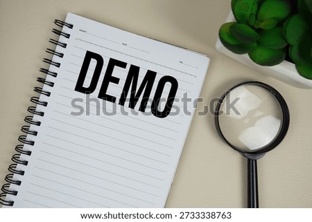 Demo text on paper notebook with magnifying glass on beige leather background