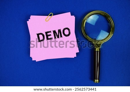 Demo text on sticky note with magnifying glass on navy blue background