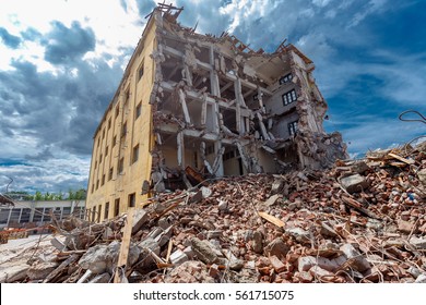 Demolished Building Surrounded With Rubble And Scrap. Deconstruction Of Building. Earthquake Ruin Scene. Destruction Concept.