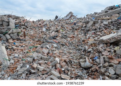 Demolished and damaged buildings after strong earthquake.  
Ruins of destroyed houses in town. Pile of bricks, dust and materials. Natural disaster.