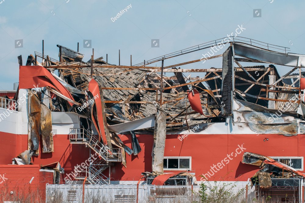 Demolished industrial building after fire with broken roof, walls and ...