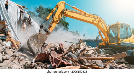 Demolition of building. Excavator breaks old house. Freeing up space for construction of new building - Shutterstock ID 2006150615