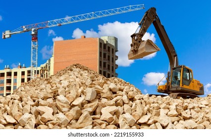 Demolition Buildings. Construction Machinery In Front Of Multistory Building. Demolition House With Excavator. Excavator Stands On Small Stones. Construction Multi-storey Building. Construction Works