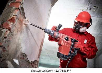 Demolition and construction destroying. worker with hammer breaking interior wall plastering