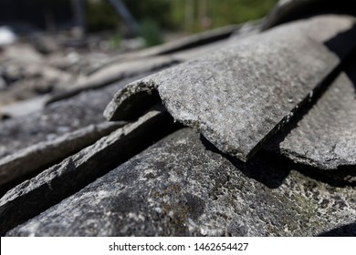 Demolition site with an asbestos issue, close-up view of the broken and fibrous slice of corrugated asbestos cement sheets