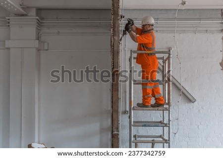 Demolition site with scaffold, workman and machinery