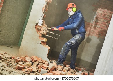 Abriss- und Umbauarbeiten. Arbeiter mit schlammzerstörender Mauer