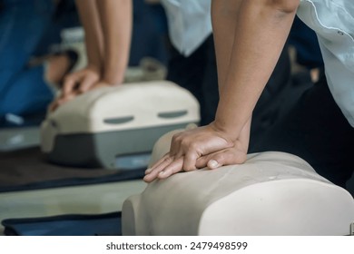 Demonstrating Cardiopulmonary resuscitation training medical procedure on CPR doll in the class.First aid for safe life  concept for people. - Powered by Shutterstock