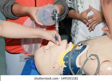 Demonstrating CPR (Cardiopulmonary Resuscitation) Training Medical Procedure On CPR Doll In The Class.Paramedic Demonstrate First Aid Practice For Save Life.Doctor Holding Breathing Bag(Ambu Bag).