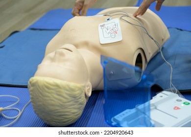 Demonstrating CPR (Cardiopulmonary resuscitation) training medical procedure on CPR doll by Automated External Defibrillator, AED technic in the class.First aid for safe life concept.