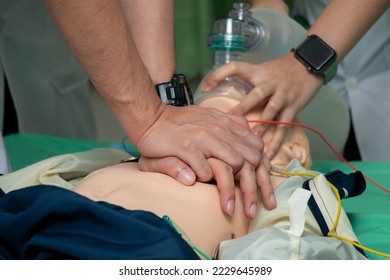 Demonstrating CPR (Cardiopulmonary resuscitation) training medical procedure on CPR doll in the class.Paramedic demonstrate first aid practice for save life.Doctor holding breathing bag(Ambu bag).