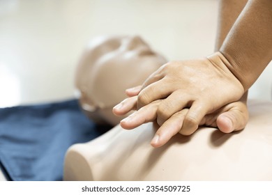 Demonstrating CPR (Cardiopulmonary resuscitation) training medical procedure on CPR doll in the class.Doctor and nurse students are learning how to rescue the patient.First aid for safe life concept. - Powered by Shutterstock