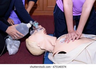 Demonstrating CPR (Cardiopulmonary Resuscitation) Training Medical Procedure On CPR Doll In The Class.