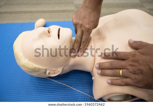 Demonstrating CPR (Cardiopulmonary\
resuscitation) training medical procedure on CPR doll in the\
class.Doctor and nurse students are learning how to rescue the\
patient.First aid for safe life\
concept.