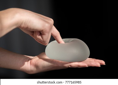 Demonstration of the properties of elasticity, softness, strength, reliability of silicone breast implant, used in plastic surgery to increase or enhance sexuality, aesthetic appeal of forms