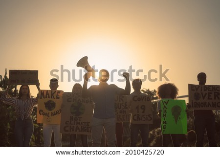 Demonstrators group protesting for climate change - Multiracial people fighting on road holding banners on environments disasters - Global warming concept