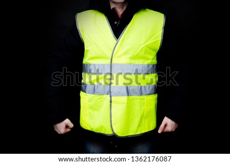 Demonstrators in yellow vests on a black background, the protest of the population in France against the increase in the cost of fuel, excessive living expenses and high taxes, gilets jaunes in French