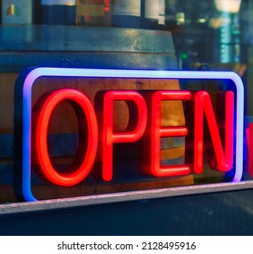 Den Haag, Netherlands - January 10 2022: A Neon Red Blue Open Sign Has Been Placed Near The Entrance Off A Shop In Front Of The Window