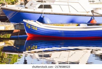 Den Helder, Netherlands. July 2022. Reflection in the water of a small fishingboat. High quality photo
