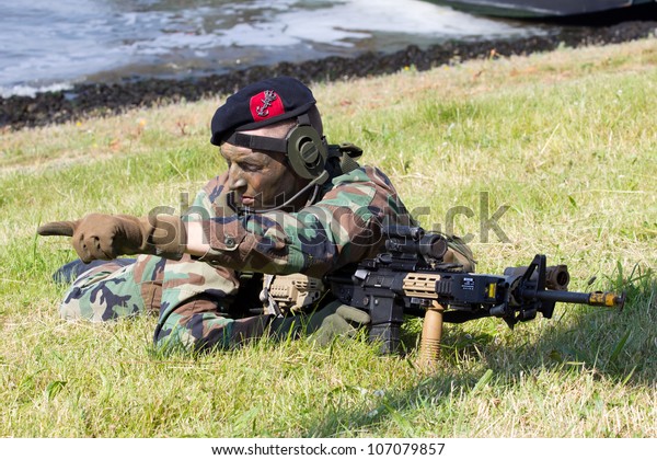 DEN HELDER,\
THE NETHERLANDS - JULY 7: A Dutch Marine giving directions during\
an amphibious assault demo during the Dutch Navy Days on July 7,\
2012 in Den Helder, The\
Netherlands