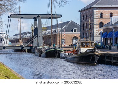 Den Helder, Noord-Holland, Netherlands, April 17, 2021. Willemsoord with boats anchored at the quay, metal bridge, brick buildings in the background, former Naval base of the Royal Navy