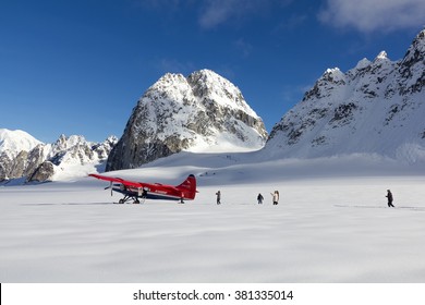 DENALI NATIONAL PARK, ALASKA, USA - SEPTEMBER 14, 2013: Tourists Walking In Deep Snow After Plane Landing On Pika Glacier Near Mount McKinley.