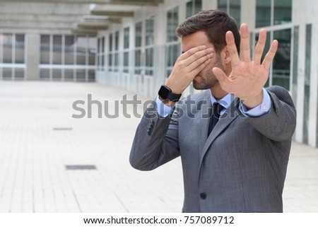 Denial concept with businessman covering his eyes