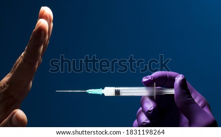 Denial of medical vaccination concept. Stop the medical injection. Refuse the vaccine medication. Protest against vaccination, man's hand rejecting preventive medicine
