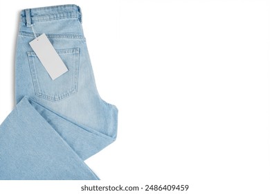 Denim blue jean, folded blue jeans pants with blank label tag, isolated on white background, top view. Back side of jeans with back pocket, mockup, template, banner, header