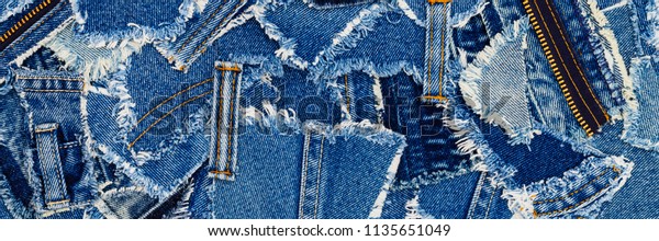 Denim blue\
jeans fabric frame. Ripped denim fabric , text place, copy space.  \
Destroyed torn denim blue jeans patches, banner background. Recycle\
old jeans denim concept