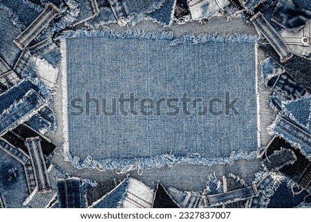 Denim blue jeans flaps frame. Ripped denim fabric. Destroyed torn denim blue jeans patches, banner background. Recycle old jeans denim pieces concept. Many fragments of jeans cloth.