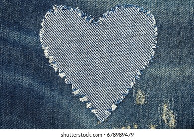 Denim jeans fashion background. Ripped denim heart frame on blue jeans background. Worn Jeans Casual Double Color patch Denim. Vintage Style Ripped Stone Wash 
 - Powered by Shutterstock