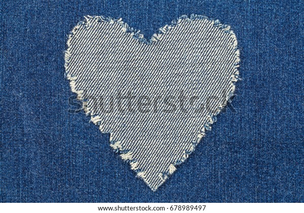 Denim jeans fashion\
background. Ripped denim heart frame on blue jeans background. Worn\
Jeans Casual Double Color patch Denim. Vintage Style Ripped Stone\
Wash \
